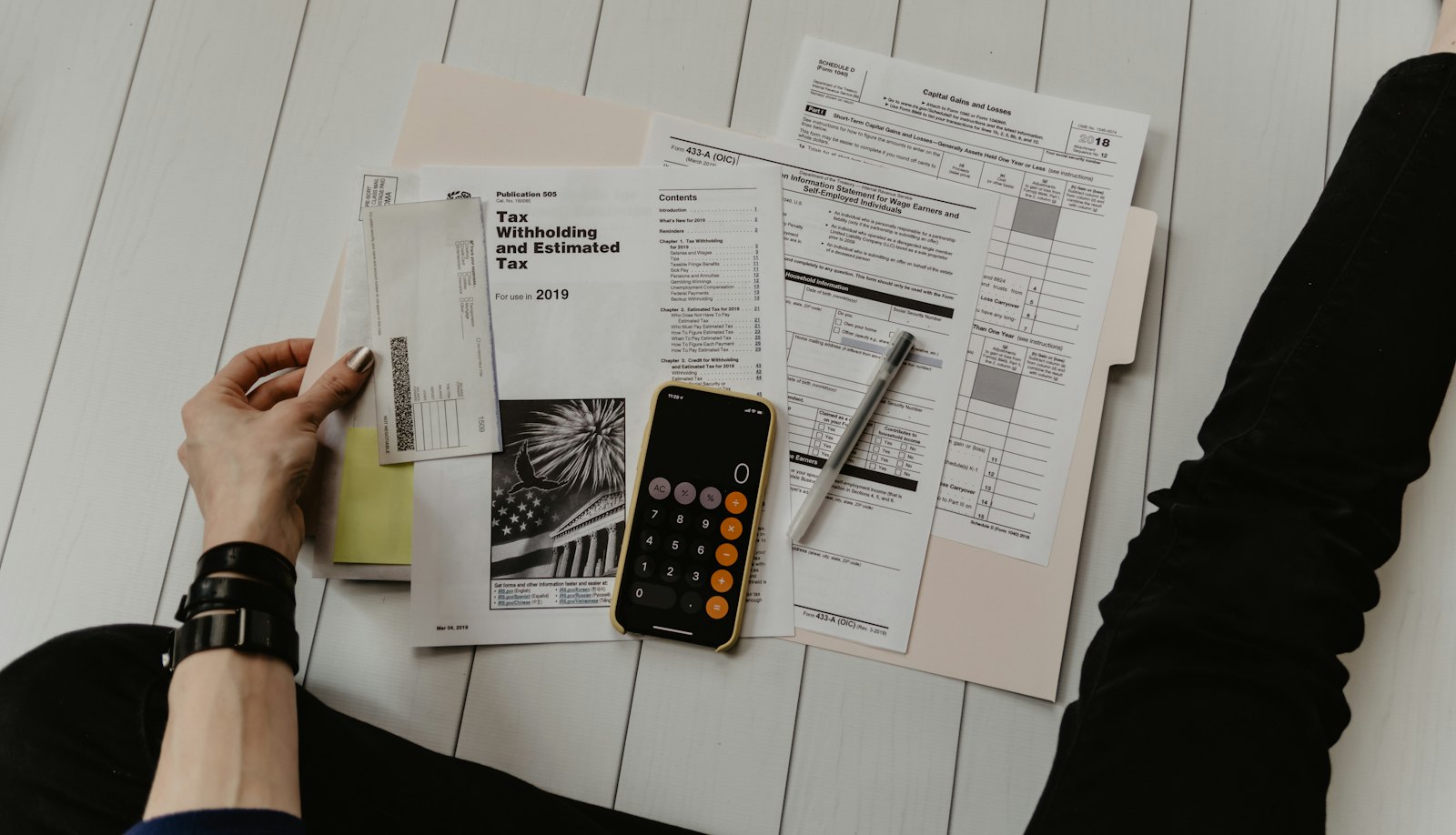 US tax forms, a calculator and a phone on a desk